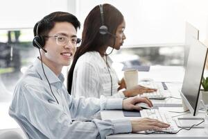 Group of positive technical support managers working on hotline at call centre. Customer service consultants providing help to clients at open space office photo