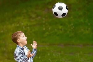 Summertime family activities. Adorable boy with his father playing soccer together on picnic in forest photo