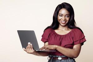 Cute young black lady freelancer using newest laptop, panorama with copy space, african american woman smiling over beige studio background. Job opportunities on Internet, remote vocations concept photo