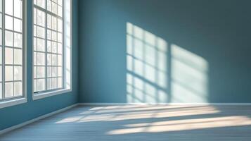 Sunlight streams through windows, casting patterns on the blue wall and light wood floor. The room is simple, minimalist, and inviting. photo