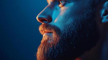 A striking portrait of a bearded man in side profile, illuminated by colorful lighting, conveying emotion, strength, and modern masculinity in a captivating manner. photo