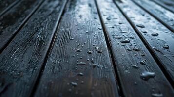 This image captures the texture of a dark wooden surface adorned with raindrops, evoking a sense of calm and tranquility often associated with rainy days. photo