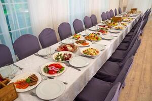 festive table set with Caesar salads beets fruit plate without people photo