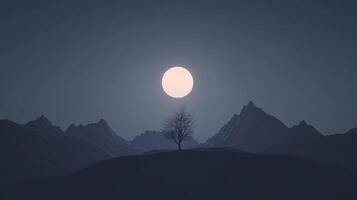 A solitary tree stands amidst shadowy mountains under the bright glow of a full moon, symbolizing strength, resilience and the beauty of isolation in nature's landscape. photo
