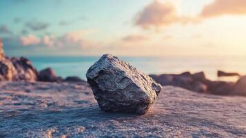 This visual captures a solitary rock on a tranquil shoreline against a backdrop of soft, colorful clouds at twilight, embodying a sense of peace and solitude. photo