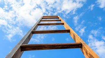 Wooden ladder extending upwards to blue sky. The rungs lead towards freedom and success against a backdrop of fluffy clouds. photo