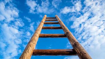 Looking up at a rustic wooden ladder ascending into a bright blue sky with scattered white clouds, symbolizing hope and upward mobility. photo