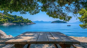 Coastal view with picnic table, islands dotting the blue sea under a clear sky, framed by tree branches creating a tranquil, inviting scene. photo