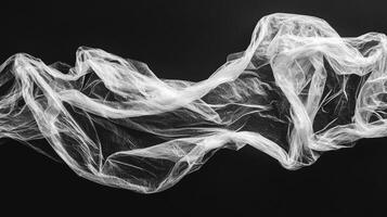 Abstract image featuring a sheer, white fabric gently draped against a stark black background, creating an ethereal wave effect. photo