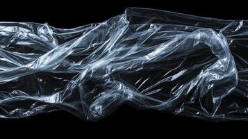 Abstract image of clear plastic sheeting with varying textures and lighting. Its folds and wrinkles create light play and shadow on the surface. photo