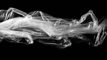 Abstract waves of translucent material cascade across a stark black canvas, creating ethereal patterns of light and shadow. photo