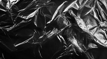 Abstract image featuring crumpled plastic, showcasing dark shades and sharp light creating compelling textural contrast. photo