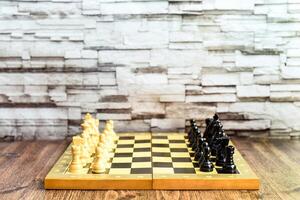 Chess pieces on chess board on wooden table. Blurred background with copy space photo