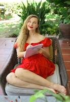 Beautiful woman artist and illustrator thinking about idea of a drawing, sitting on a couch photo