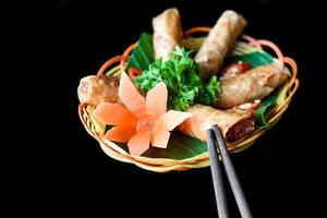 Traditional fried vietnamese spring rolls with pork rice paper on the black background side view photo
