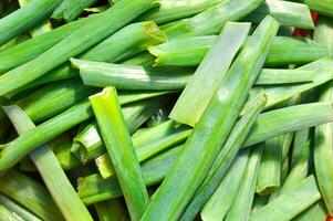 First fresh green onions chopped into pieces in wicker basket photo