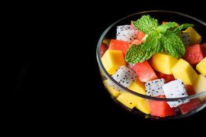 Fruit salad made of fruits isolated on black background side view photo