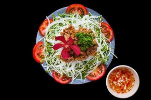 Vietnamese fried beef with salad and sauce on a black background for a menu photo