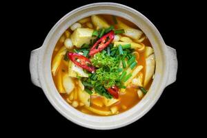 Vietnamese vegetairan soup with tofu, mushrooms and vegetables isolated on black background top view photo