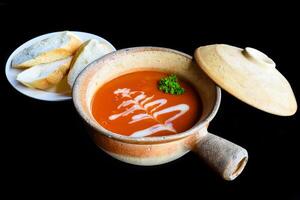 Tomato Cream Soup isolated on black background side view photo