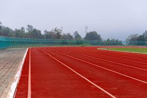 Empty running track in stadium Close up of athlete track or jogging track in university or college campus and building. photo