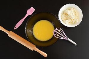 Making curd biscuits. melted butter and sugar in a bowl next to curd and kitchen utensils. photo