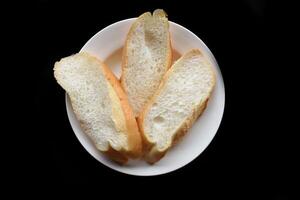 Sliced Vietnamese traditional Banh Mi baguette on a black background photo