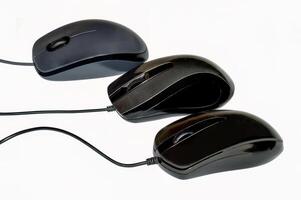 Three optical computer mouse devices in a row isolated on white background photo