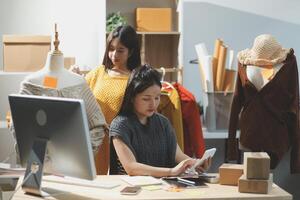 Two women working on a computer in a clothing store photo