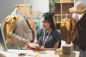 A woman is working at a desk in front of a mannequin photo