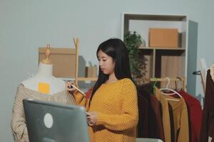 A woman is looking at a computer screen while wearing a yellow sweater photo