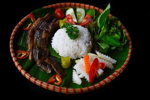 Smoked eel with rice and vegetables isolated on a black background top view photo