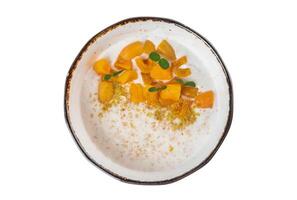Oatmeal with milk served with fresh apricot on white background top view photo