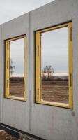 A concrete building with windows and a field in the background photo