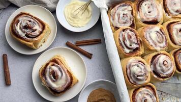 Freshly baked cinnamon rolls covered with icing on concrete background video