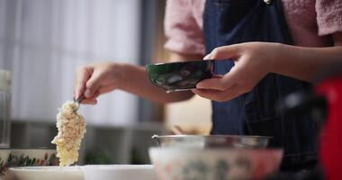Hands of Beautiful woman is preparing the process of coating chicken with all the ingredients in a bowl before frying the chicken on a pan. Cooking concept, Food preparation video