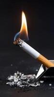 Smoldering cigarette on a black background photo