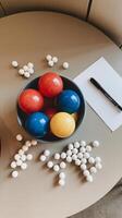 A bowl of colorful eggs and a pen on a table photo