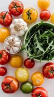 Tomatoes, garlic, and arugula on white table photo