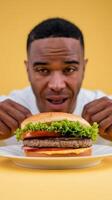 A man is holding a hamburger in front of him photo