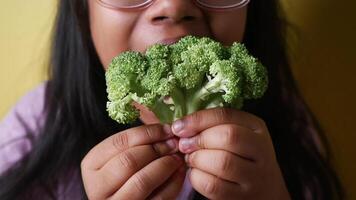Holding fresh broccoli with excitement in a colorful setting video
