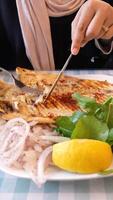 Enjoying grilled fish with vegetables and lemon at local eatery video