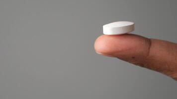 Holding a white tablet on a fingertip in a simple background video