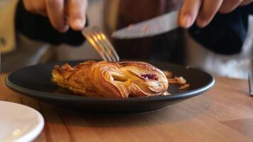 Slicing into a flaky pastry at a cozy cafe video