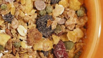 Crunchy granola mix with fruits and nuts in a bowl video