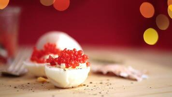 hervido huevos con rojo caviar en un borroso nuevo años antecedentes. video