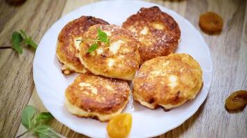 Fresh cottage cheese pancakes with pieces of dried apricots video