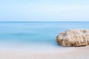 Rock on serene beach, Tranquil seaside scene with azure waters, clear sky, and sandy shore photo
