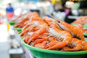 Fresh cooked seafood displayed, vibrant orange prawns in a green container, ready for consumption photo