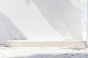 Minimalist display platform against a crisp white wall, bathed in soft shadows and bright sunlight photo